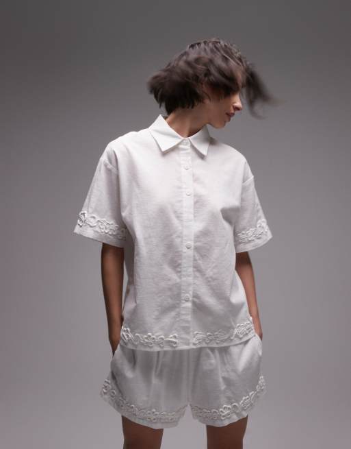 SNDYS - Camicia bianca in misto lino a maniche corte con fiori applicati in coordinato