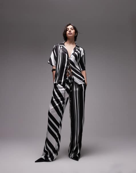 SNDYS – Gestreiftes Set in Schwarz-Weiß, aus weit geschnittener Hose und kurzärmliger Hemdbluse mit gebundener Vorderseite und Kragen - view 1