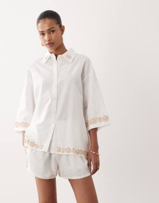 SNDYS - Oversize-Hemdbluse aus Leinen-Baumwollmix in Weiß mit Blumenapplikation am Rand, Kombiteil