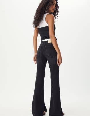 Stradivarius - Ausgestellte Jeans in schwarzer Rinse-Waschung mit Saumschlitz