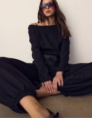 Stradivarius - Langärmliges T-Shirt in Schwarz mit U-Boot-Ausschnitt und Kummerbund-Saum