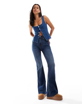 Stradivarius - Schlagjeans in überfärbtem Blau mit Schlitz