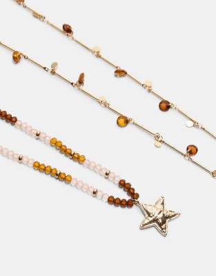 Stradivarius - Set mit 2 Halsketten in Gold-Optik mit Perlen- und Sternverzierung-Gelb