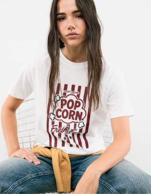Stradivarius - T-Shirt in Weiß mit Strassverzierung sowie „Popcorn"-Grafikmotiv und Textprint
