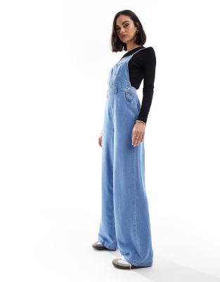 Stradivarius - Weicher Denim-Jumpsuit in Hellblau mit überkreuzten Rückenträgern