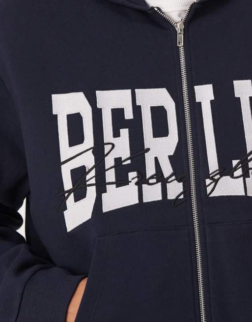Sudadera azul marino de corte cuadrado con capucha, cremallera y estampado "Berlin" de ASOS DESIGN, 2 de 4