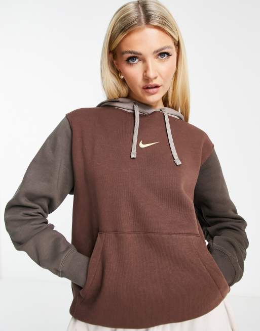 Sudadera color marron y tonos neutros oscuros con capucha diseno color block y logo metalizado de Nike