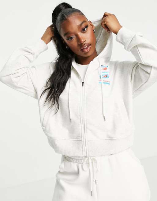 Sudadera gris con capucha, cremallera y etiqueta con logo de New Balance