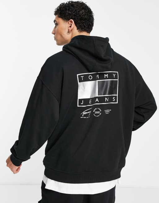 Sudadera negra holgada con capucha y estampado de bandera en la espalda de la colección cápsula Metallic de Tommy Jeans