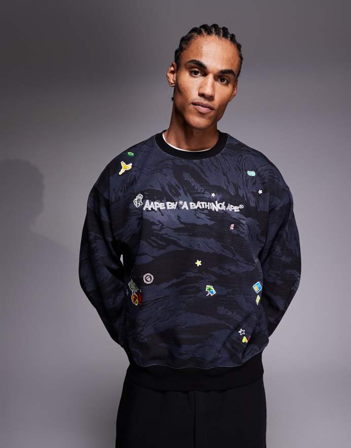 Aape By A Bathing Ape® Sudadera negra sin cierres con estampado de camuflaje y pegatinas adorables de