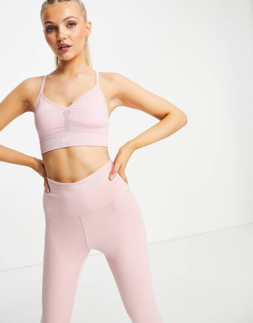 Sujetador rosa deportivo de tirantes y sujeción ligera sin costuras Indy de Nike Yoga