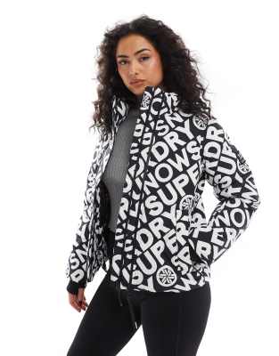 Superdry - Ski - Kastige Puffer-Jacke in Schwarz mit „Superdry"-Monogrammmuster