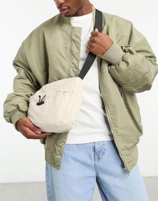 SVNX sling bag with drawstring front pocket in off white