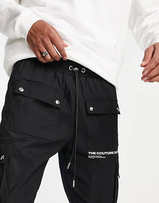 Men The Couture Club definition piped cargo trousers in black with 3D pockets 