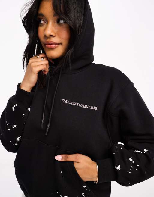 The Couture Club – Kapuzenpullover in Schwarz mit Farbspritzmuster