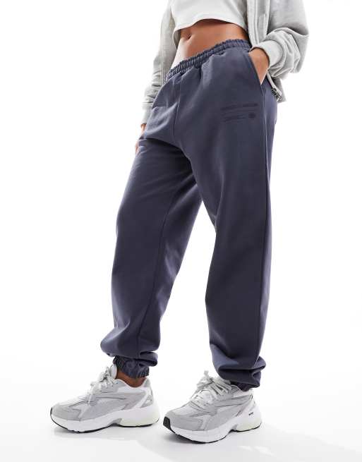 The Couture Club – Locker geschnittene Jogginghose in Petrolblau mit Grafikprint