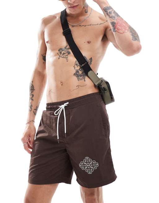 The Couture Club script print swim shorts in brown