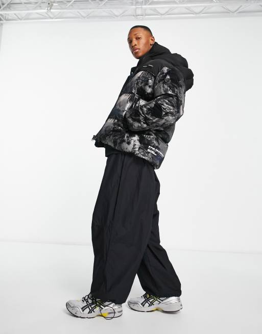 The Couture Club – Steppjacke mit Kapuze und reflektierendem Bergprint in Bahnendesign