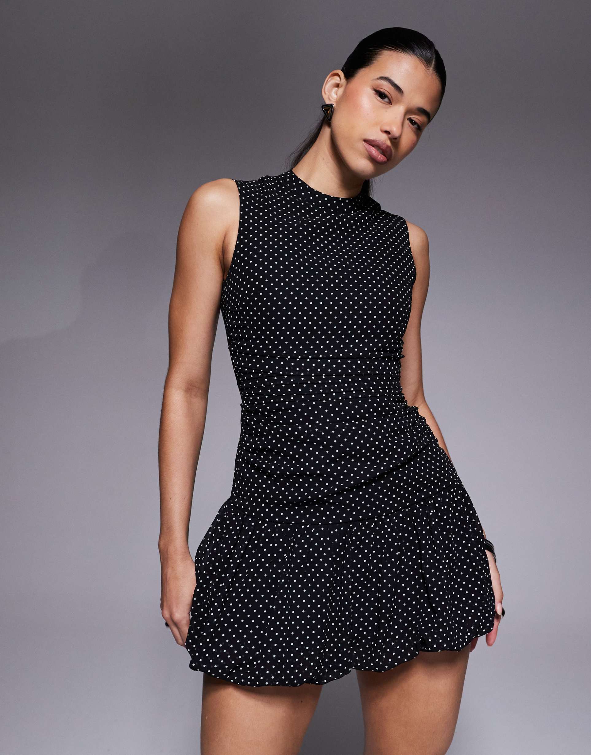 the frolic exclusive sleeveless high neck pleated drop hem dress in black polka dot