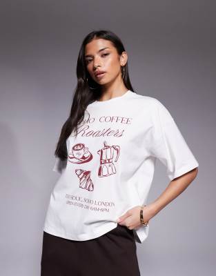 The Frolic - Exklusives Oversize-T-Shirt aus Baumwolle in Cremeweiß mit überschnittenen Schultern und „Coffee"-Grafikpri...