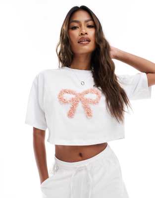 The Frolic – Vit, exklusiv t-shirt i kort design med boxig passform och tyllrosett 