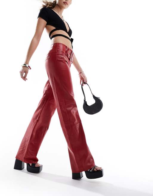 The Kript Y2K low rise trousers in red faux leather with silver belt detail