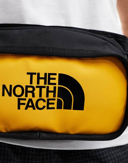 The North Face logo hip pack bag in black and yellow | ASOS