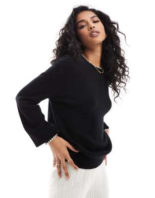 black knitted sweater with white contrast trim