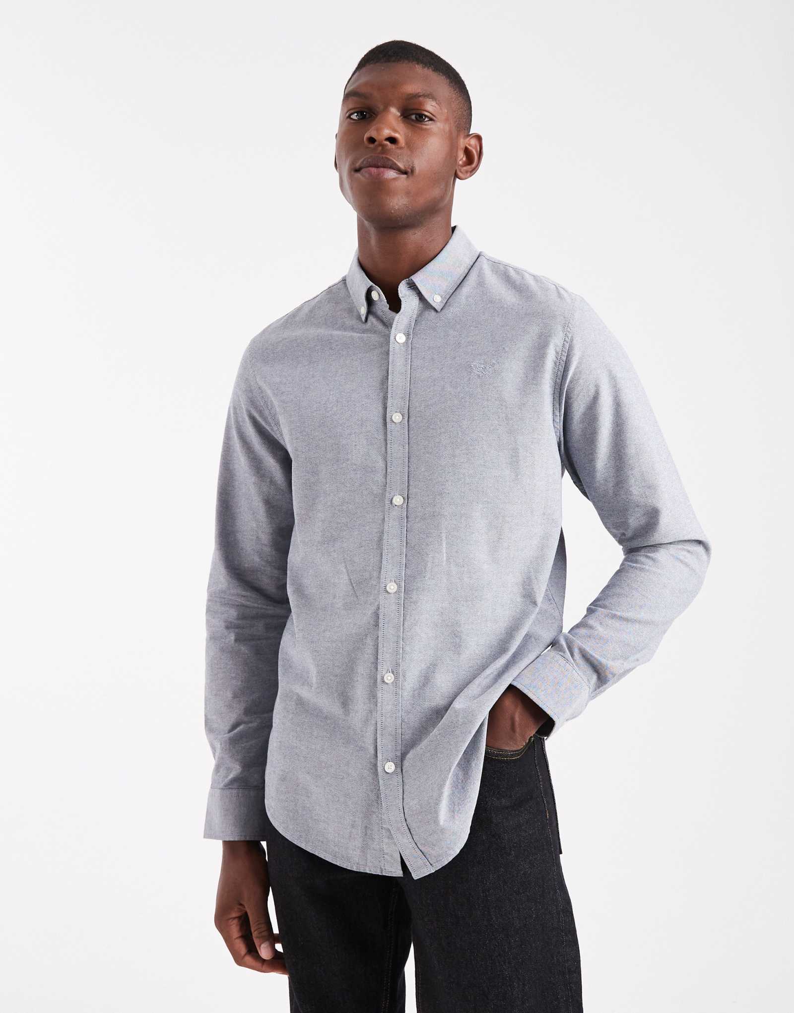 Поношенная оксфордская рубашка с длинным рукавом синего джинсового цвета