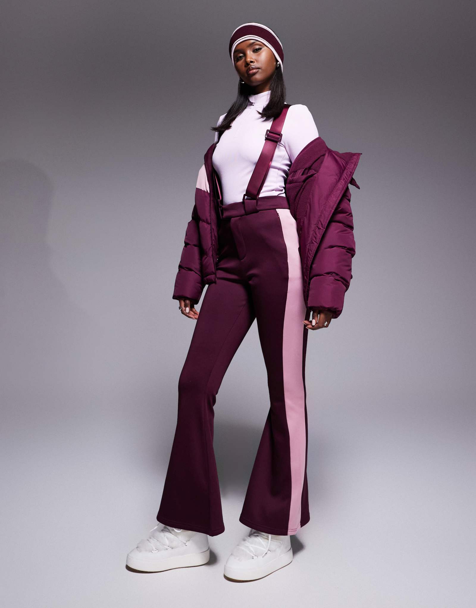 Поношенный лыжный комбинезон с контрастными вставками бордового и розового цветов 