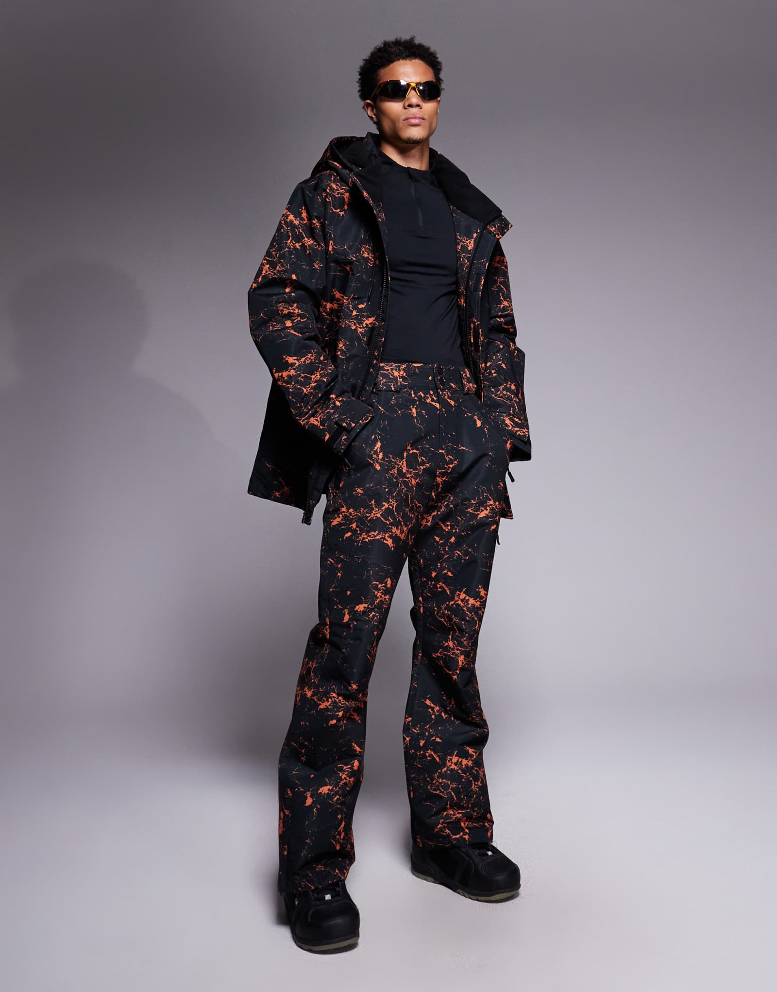 Поношенные лыжные брюки с черно-оранжевым принтом