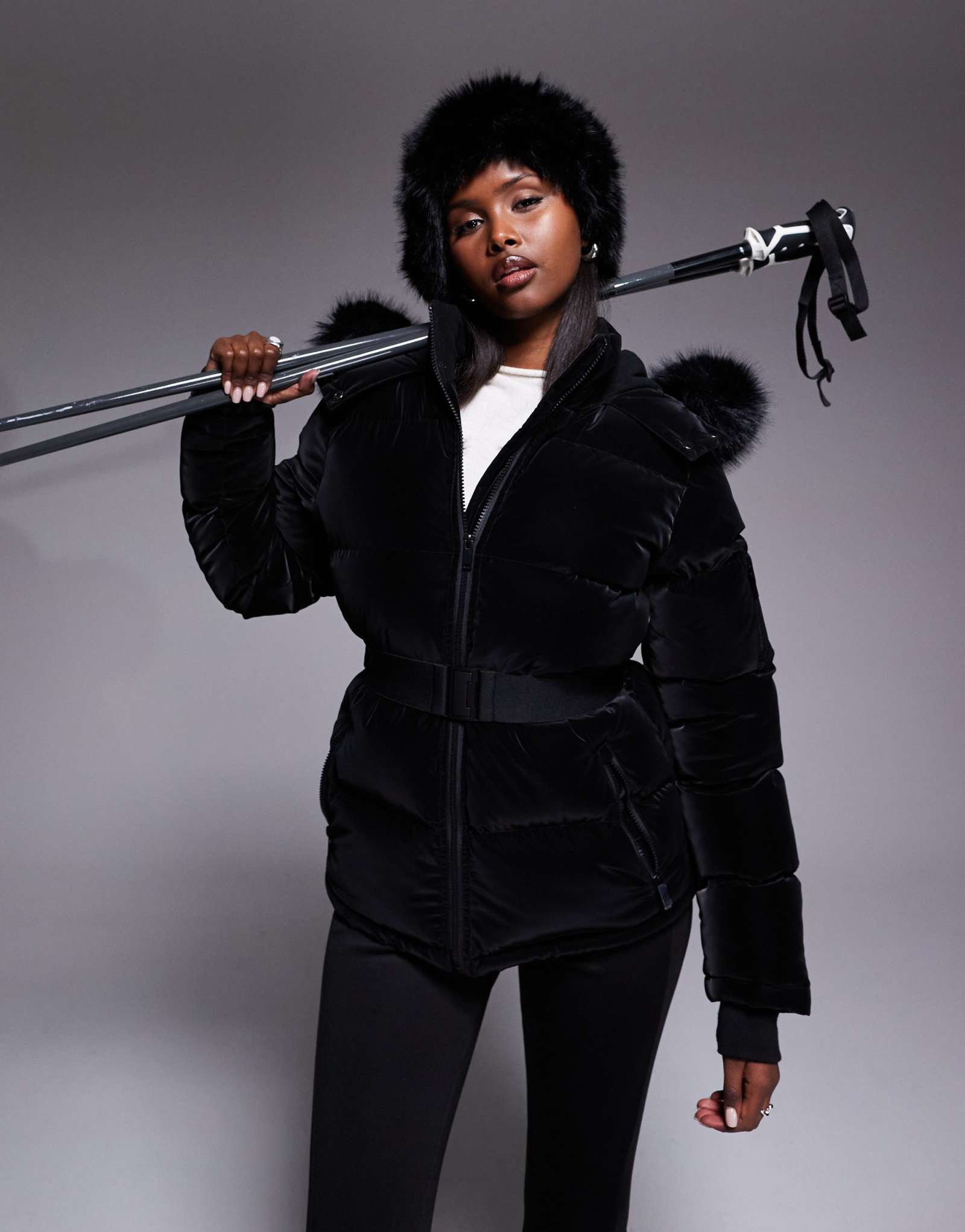 Поношенная лыжная куртка-пуховик с воротником из искусственного меха черного цвета