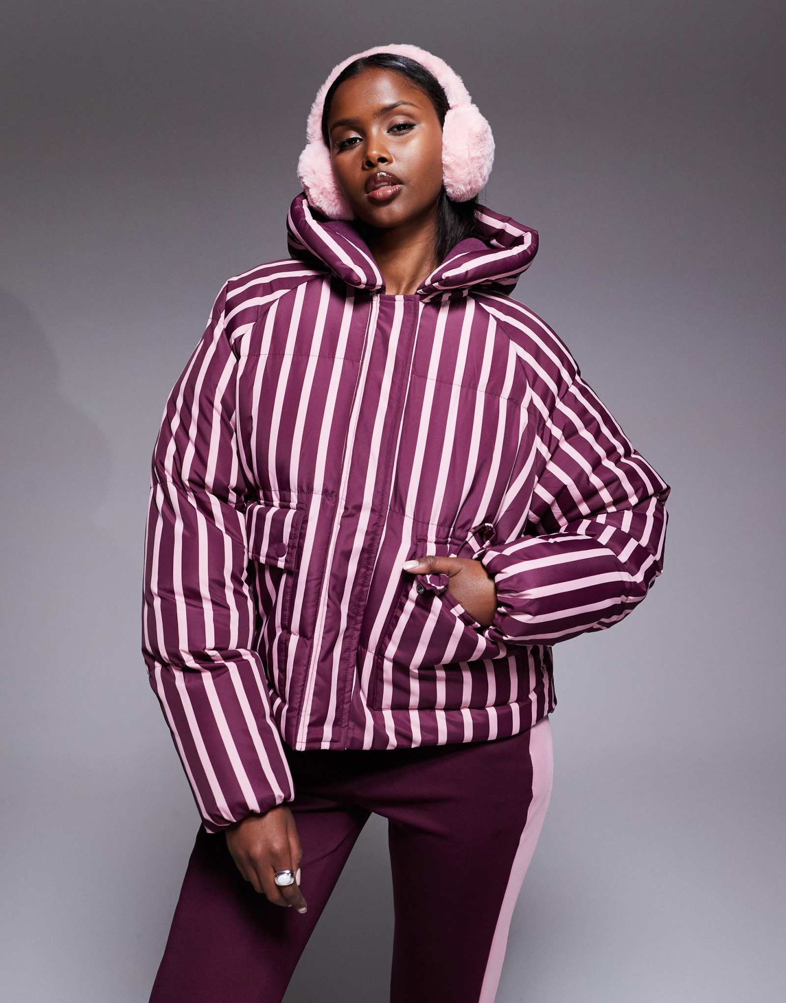 Поношенное лыжное пуховое пальто в полоску с капюшоном бордового и розового цветов