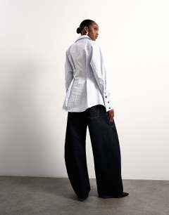 Model wearing Tolu Coker x Topshop barrel high rise jean circular design in indigo rinse