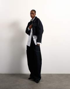 Model wearing Tolu Coker x Topshop barrel high rise jean circular design in indigo rinse