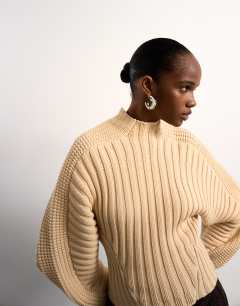 Model wearing Tolu Coker x Topshop knitted ovoid sleeve jumper in beige