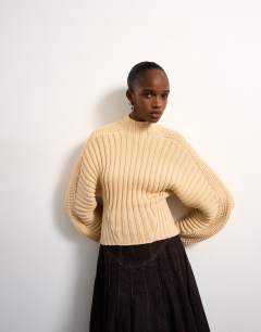 Model wearing Tolu Coker x Topshop knitted ovoid sleeve jumper in beige