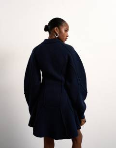 Model wearing Tolu Coker x Topshop knitted ovoid sleeve structured dress in navy