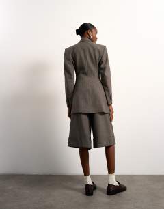 Model wearing Tolu Coker x Topshop tailored longline short in taupe