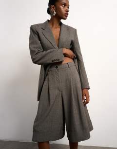 Model wearing Tolu Coker x Topshop tailored longline short in taupe
