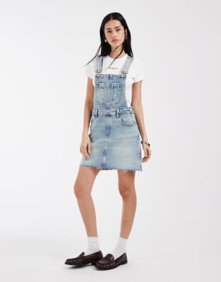 Tommy Jeans – Ljusblå, tvättad hängselklänning i denim — klänning med fickor från ASOS