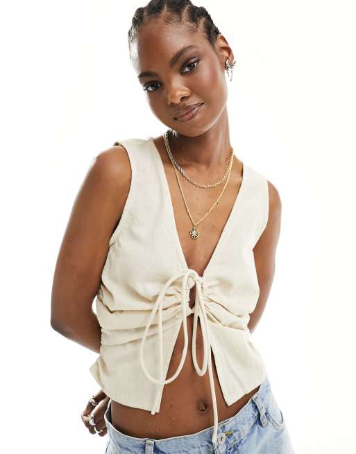 Top color crema sin mangas con detalle de lazada ajustable de lino y algodón de COLLUSION