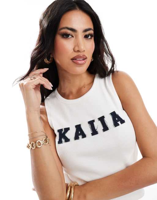 Top largo blanco sin mangas con aplicación vaquera del logo de Kaiia