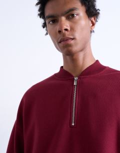 Model wearing 1/4 zip bomber in burgundy