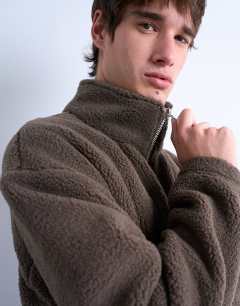 Model wearing 1/4 zip borg sweatshirt in  dark brown