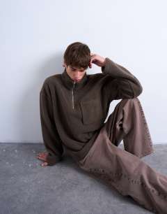 Model wearing 1/4 zip borg sweatshirt in  dark brown