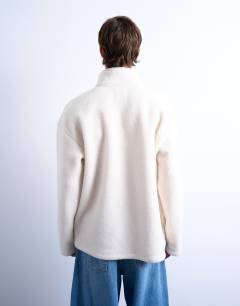 Model wearing 1/4 zip borg sweatshirt in ecru
