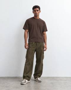 Model wearing 3 pack relaxed fit t-shirt in black, ecru and brown