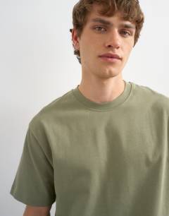 Model wearing 3 pack relaxed fit t-shirt in white, black and olive