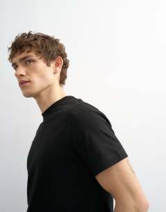 Model wearing 5 pack classic fit t-shirt in black, white, navy, olive and stone 